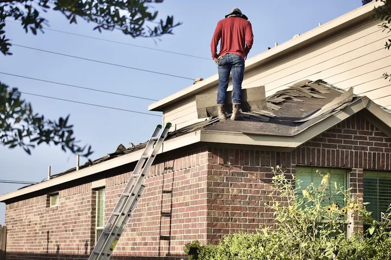 Professional roofer working on a residential roof in Little France